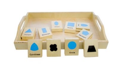 Este material Montessori consiste en una caja de madera que contiene 10 piezas de madera con dibujos de figuras geómetricas por un lado y por el otro lado es un sello de la misma figura,vista frontal,foto redes sociales,mmm399